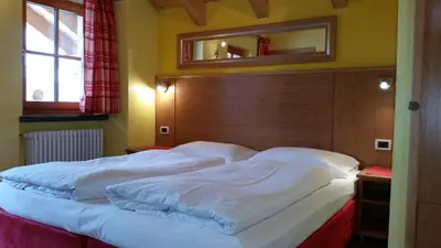a bedroom with a large bed with a wooden headboard at Chalet Heidi in Arabba