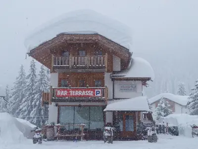 a snow covered building with a sign on it at Chalet Heidi in Arabba
