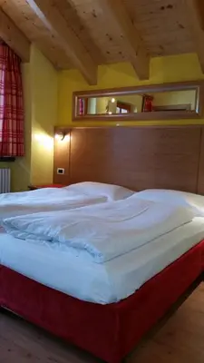 a bedroom with a large bed with a wooden headboard at Chalet Heidi in Arabba