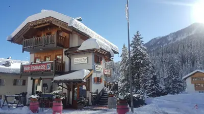 a large building with snow on it in the mountains at Chalet Heidi in Arabba