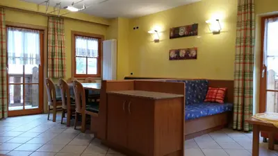 a living room with a table and a blue couch at Chalet Heidi in Arabba