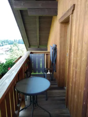 a small table on the balcony of a tiny house at Huberhof Abendsonne in Terento