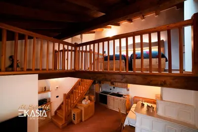 an overhead view of a living room with a wooden staircase at Al Soladif - Mansarda con vista in Cavalese