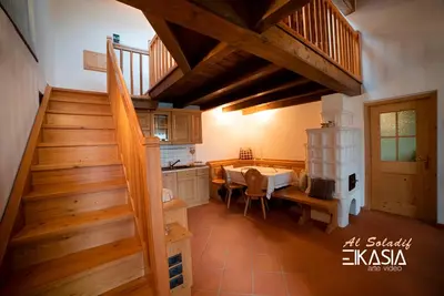 a kitchen and dining room with a staircase in a house at Al Soladif - Mansarda con vista in Cavalese