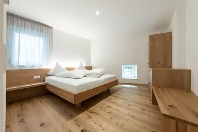a white bedroom with a bed and a window at Kati`s Guesthouse-Zentral in Kaltern in Caldaro