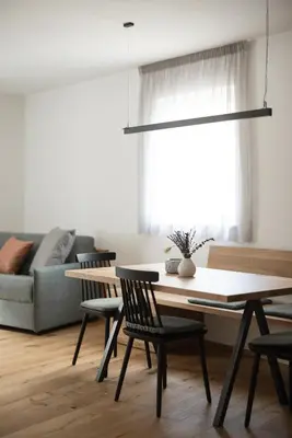 a table and chairs in a living room with a couch at Kati`s Guesthouse-Zentral in Kaltern in Caldaro