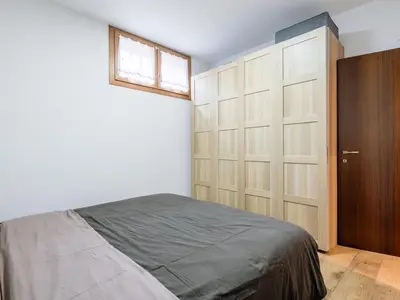 a bedroom with a large bed and a mirror at Apartment Cesa del sass by Interhome in Alba di Canazei
