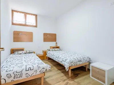 two beds in a room with white walls and wooden floors at Apartment Cesa del sass by Interhome in Alba di Canazei