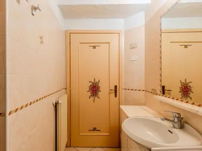a bathroom with a sink and a yellow door at Apartment Vento Alpino-4 by Interhome in Predaia