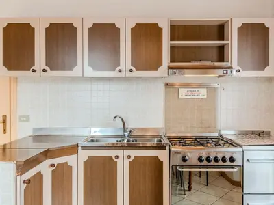 a kitchen with white cabinets and a sink at Apartment Vento Alpino-4 by Interhome in Predaia