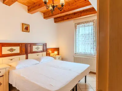 a bedroom with a white bed and a window at Apartment Vento Alpino-4 by Interhome in Predaia