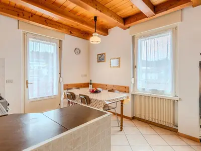 a kitchen with a table and two windows at Apartment Vento Alpino-4 by Interhome in Predaia