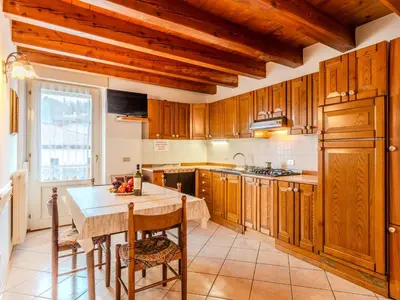 a kitchen with wooden cabinets and a wooden table at Apartment Vento Alpino-1 by Interhome in Predaia