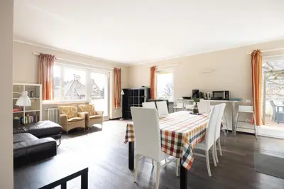 a living room with a table and chairs and a kitchen at Apartment Vicolo Sabbia in Bolzano