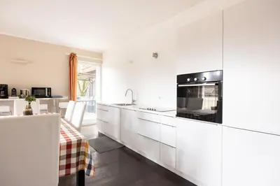 a kitchen with white cabinets and a black appliance at Apartment Vicolo Sabbia in Bolzano