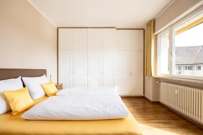 a bedroom with a bed with yellow pillows and a window at Apartment Vicolo Sabbia in Bolzano