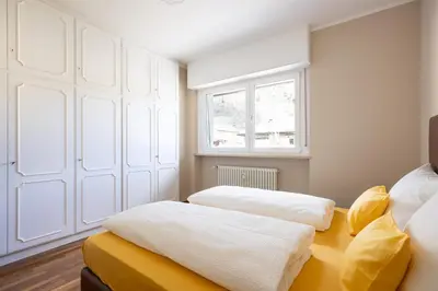 two beds in a room with a window at Apartment Vicolo Sabbia in Bolzano