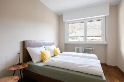 a bedroom with a bed with yellow pillows and a window at Apartment Vicolo Sabbia in Bolzano