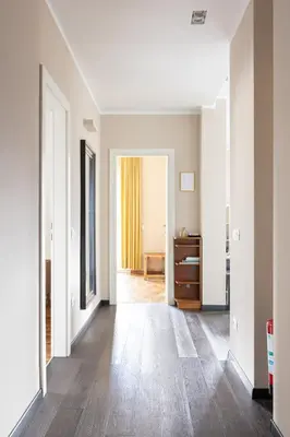 an empty hallway with white walls and wood floors at Apartment Vicolo Sabbia in Bolzano