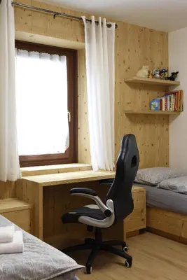 a bedroom with a desk and a chair in front of a window at Appartamento Fontanive in Masarè