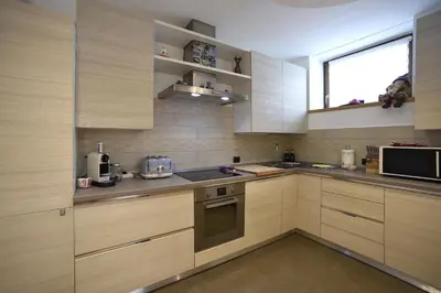 a large kitchen with wooden cabinets and a window at Appartamento Fontanive in Masarè