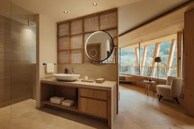a bathroom with a sink and a mirror at Taubers Bio Vitalhotel in Chienes