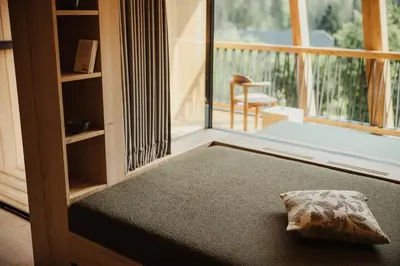 a room with a bed and a large window at Taubers Bio Vitalhotel in Chienes