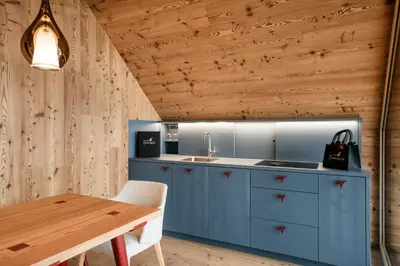 a kitchen with blue cabinets and a wooden table at OBERBUCHFELDER historic farmhouse in Laion
