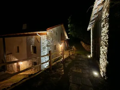 an alley at night with lights on the side of a building at OBERBUCHFELDER historic farmhouse in Laion