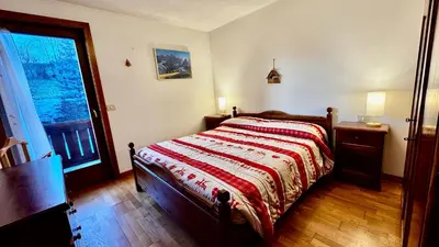 a bedroom with a bed with a red and white blanket at Cavalese view in Cavalese