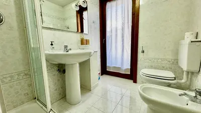 a white bathroom with a sink and a toilet at Cavalese view in Cavalese