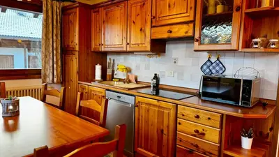 a kitchen with wooden cabinets and a sink and a microwave at Cavalese view in Cavalese