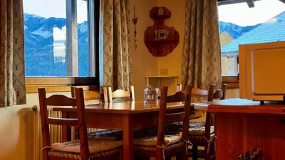 a dining room with a table and chairs and a window at Cavalese view in Cavalese