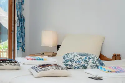 a bedroom with a bed with pillows and a window at B&B Casa Nadia in Tesero