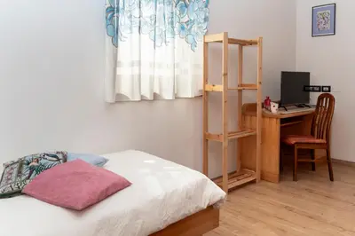 a bedroom with a bed and a desk and a window at B&B Casa Nadia in Tesero