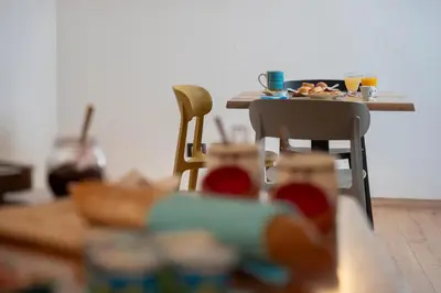 a table with a plate of food and two chairs at B&B Casa Nadia in Tesero