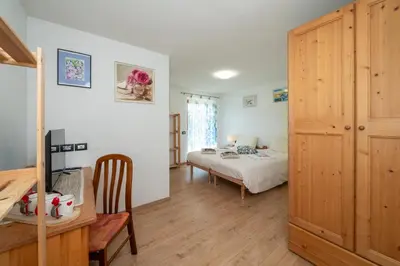 a bedroom with a bed and a desk and a table at B&B Casa Nadia in Tesero
