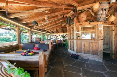 a living room with wooden ceilings and a table at Residence Untermösslhof - La Villa in Lana