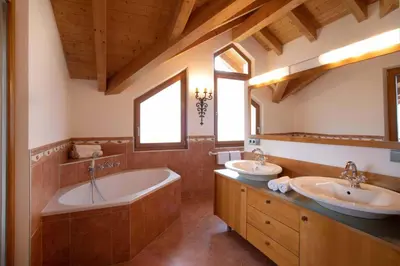 a bathroom with two sinks and a tub at Residence Untermösslhof - La Villa in Lana