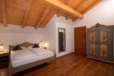 a bedroom with a bed and a wooden ceiling at Residence Untermösslhof - La Villa in Lana