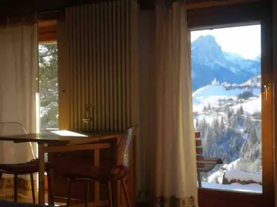 a dining room with a table and a large window at LA VOCE DEL BOSCO Selva di Cadore in Selva di Cadore
