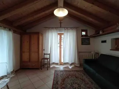 a living room with a couch and a window at LA VOCE DEL BOSCO Selva di Cadore in Selva di Cadore