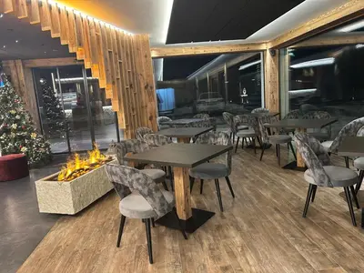 a restaurant with tables and chairs and a fireplace at Dolomites Room and Breakfast Formiè in Vigo di Fassa