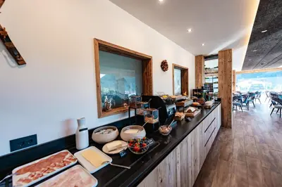 a kitchen with a counter with food on it at Dolomites Room and Breakfast Formiè in Vigo di Fassa
