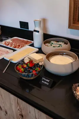 a counter top with plates and bowls of food on it at Dolomites Room and Breakfast Formiè in Vigo di Fassa