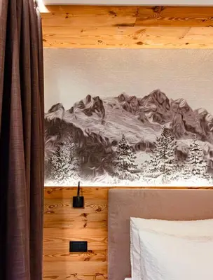 a bedroom with a drawing of a mountain on the wall at Dolomites Room and Breakfast Formiè in Vigo di Fassa