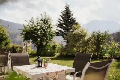 a white table with chairs and a table with flowers on it at Pension Torr in San Martino in Badia