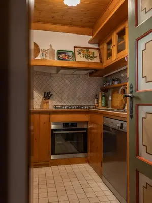 a kitchen with wooden cabinets and a stove top oven at Casa La Montanina, a due passi dal centro di Cortina in Cortina dʼAmpezzo