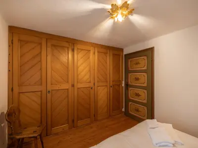 a bedroom with wooden cabinets and a ceiling fan at Casa La Montanina, a due passi dal centro di Cortina in Cortina dʼAmpezzo