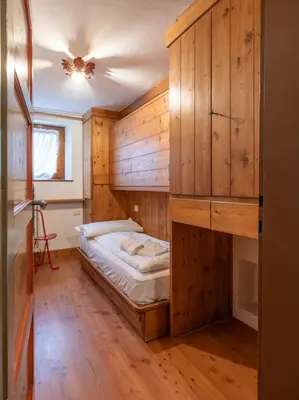 a bedroom with a bed in a room with wooden walls at Casa La Montanina, a due passi dal centro di Cortina in Cortina dʼAmpezzo